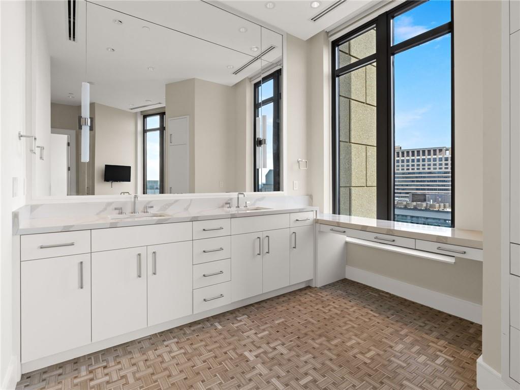 3376 Peachtree Road Northeast, Unit 35B Atlanta, GA 30326 - Photo 56 of 80 a bathroom with a granite countertop sink and a large mirror next to a window