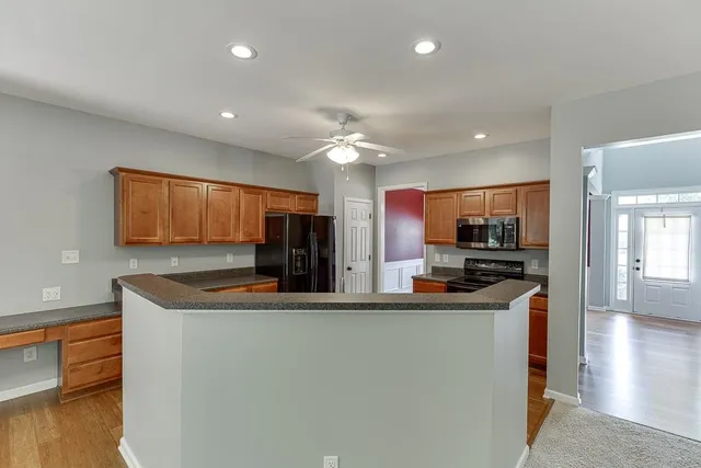a kitchen with stainless steel appliances granite countertop a sink a stove and a refrigerator