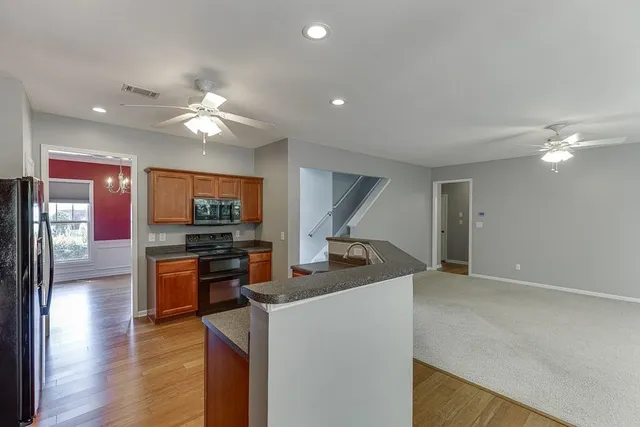 a view of a kitchen with a sink a refrigerator and wooden floor