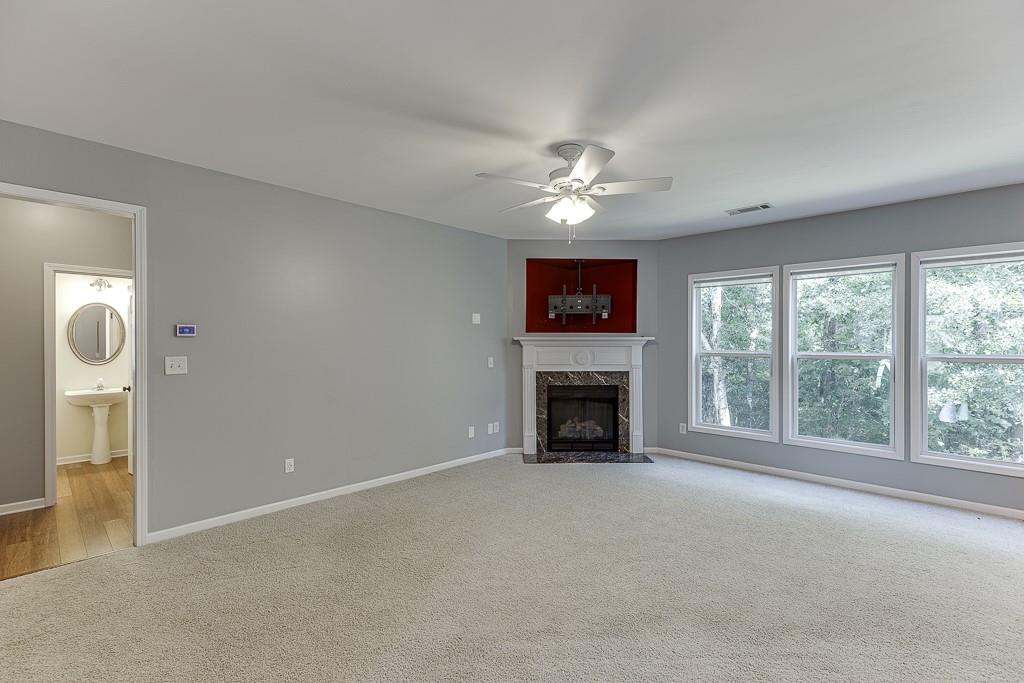2365 Valley Mill Drive Buford, GA 30519 - Photo 18 of 53 an empty room with windows fireplace and fan