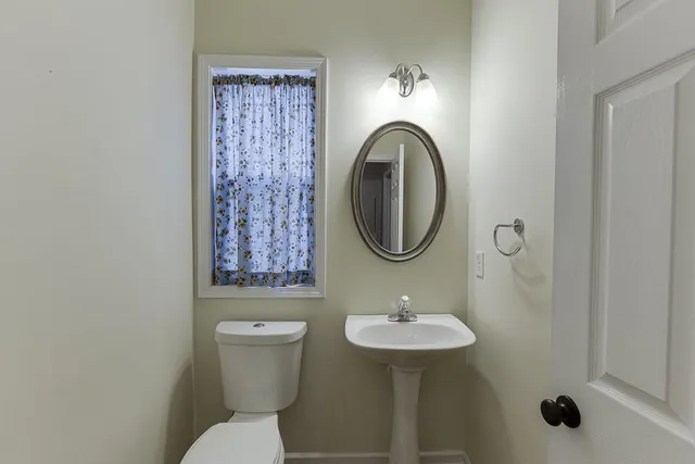a bathroom with a sink a toilet and a mirror