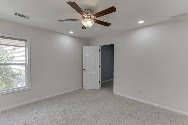 an empty room with a ceiling fan and a window