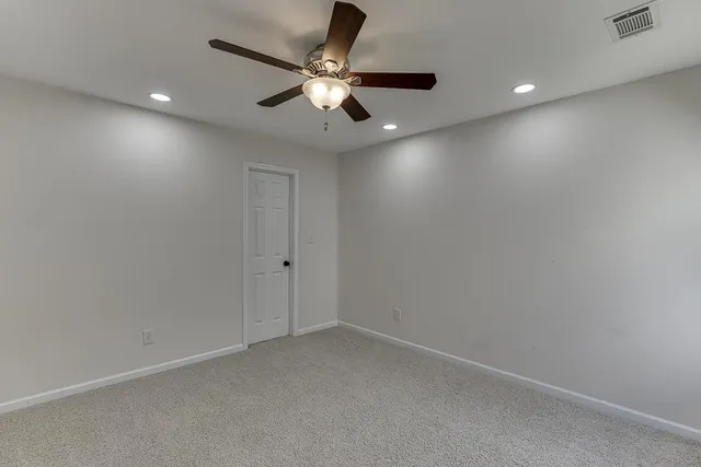 an empty room with a window and a ceiling fan
