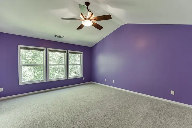 a big room with chandelier fan and windows