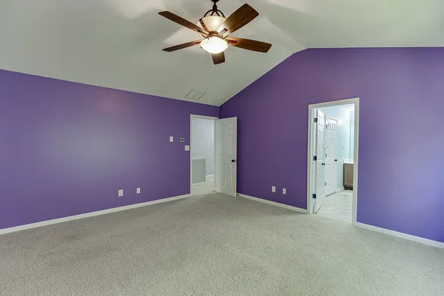 a big room with windows and a ceiling fan