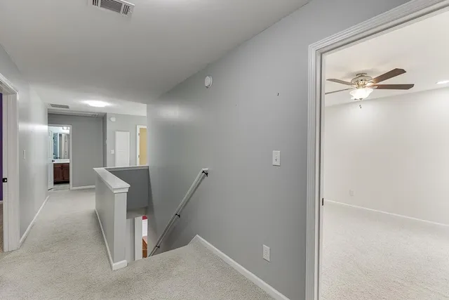 a view of an empty room with a chandelier fan