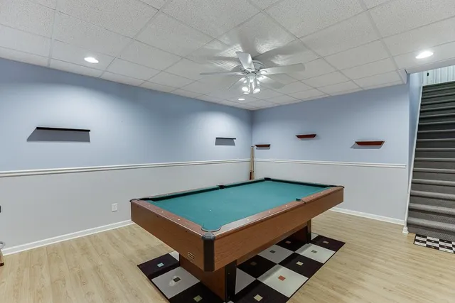 a room with pool table and windows