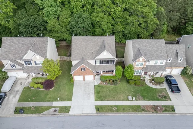 an aerial view of a house with a yard and large trees