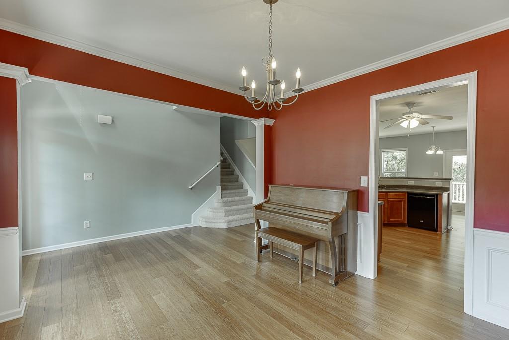 2365 Valley Mill Drive Buford, GA 30519 - Photo 6 of 53 a room with wooden floor a chandelier a fireplace and entryway