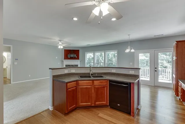 a kitchen with granite countertop a stove and a wooden floors