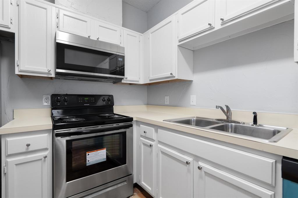 5310 Keller Springs Road, Unit 626 Dallas, TX 75248 - Photo 7 of 13 a kitchen with white cabinets stainless steel appliances and sink