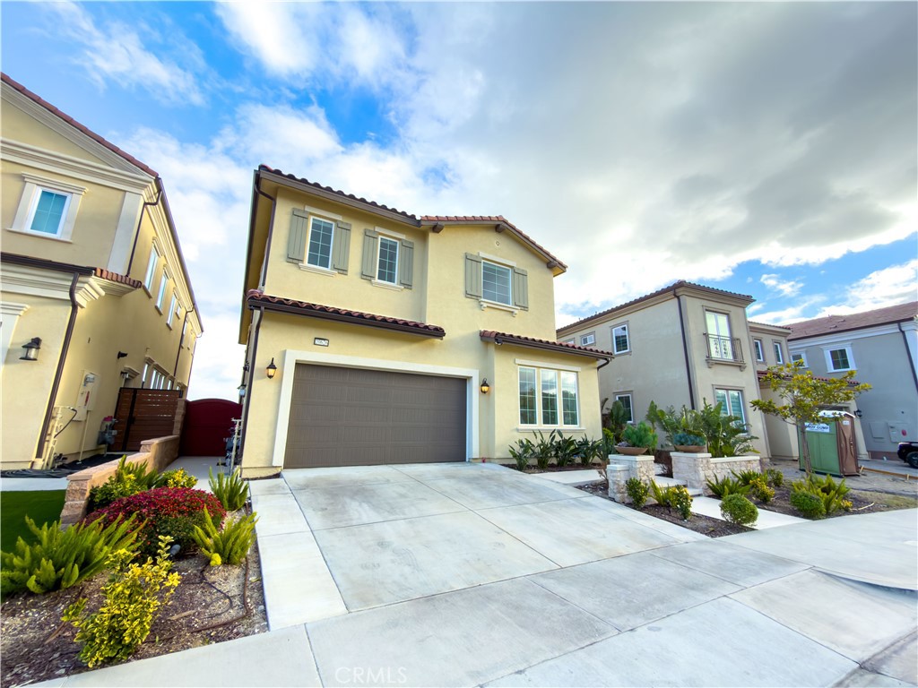 20626 Deer Grass Court Porter Ranch, CA 91326 - Photo 3 of 45 a front view of a house with a garden and outdoor seating