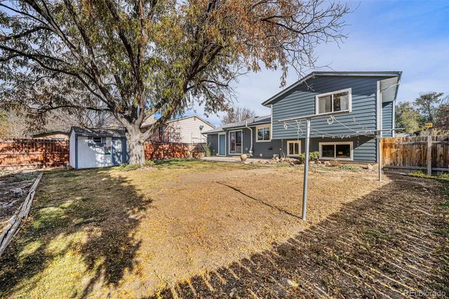 a view of a white house with a large tree