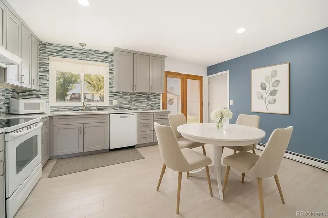a kitchen with stainless steel appliances a dining table and chairs