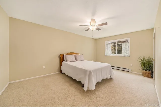 a bedroom with a bed and a ceiling fan
