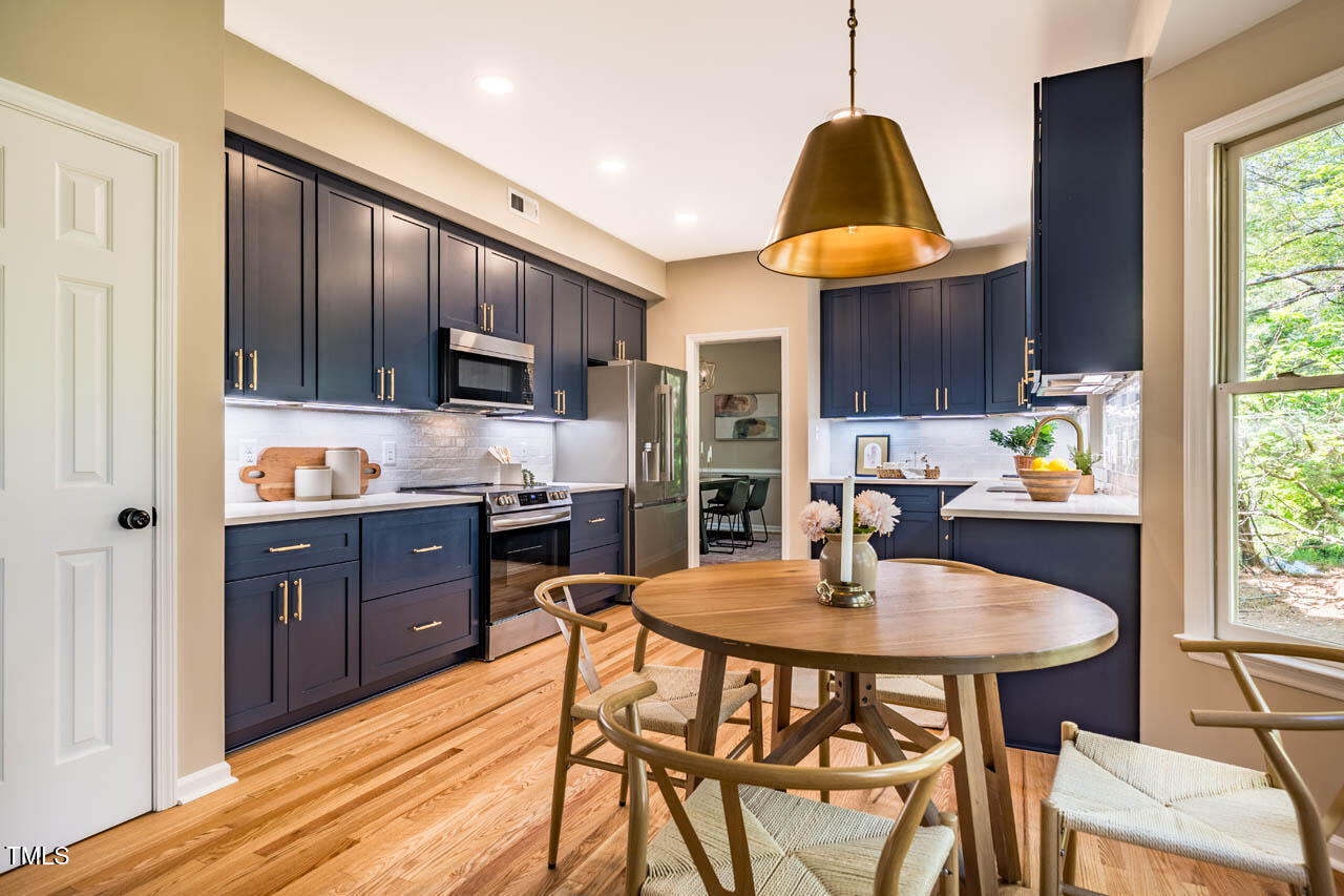 103 Windhover Drive Chapel Hill, NC 27514 - Photo 17 of 61 a kitchen with a dining table and chairs