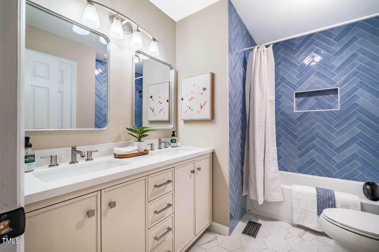 103 Windhover Drive Chapel Hill, NC 27514 - Photo 40 of 61 a bathroom with a sink a toilet a mirror a vanity and shower