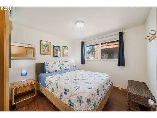 a bedroom with a bed a dresser and next to a window