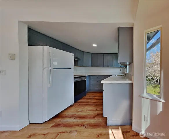 a kitchen with a refrigerator sink and cabinets