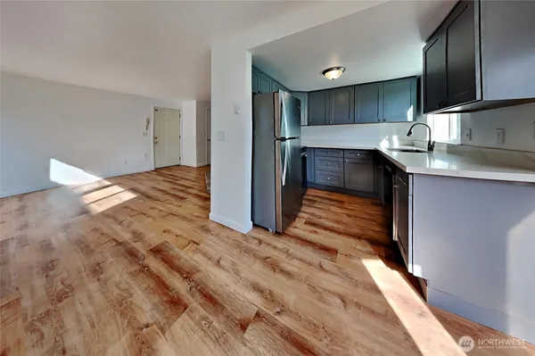 a view of kitchen with sink and refrigerator