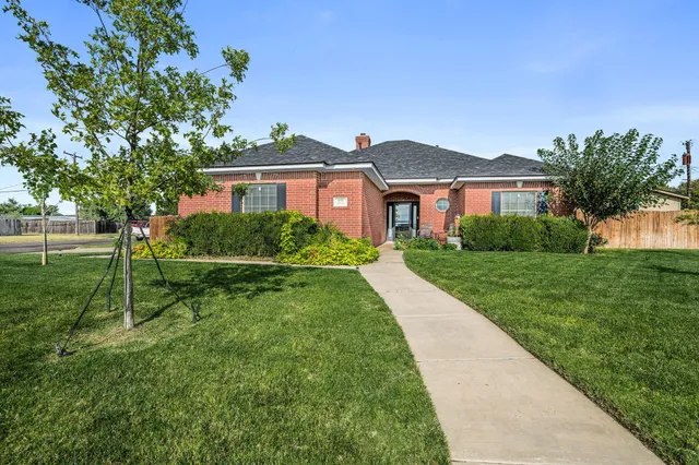 a view of house with a big yard and potted plants