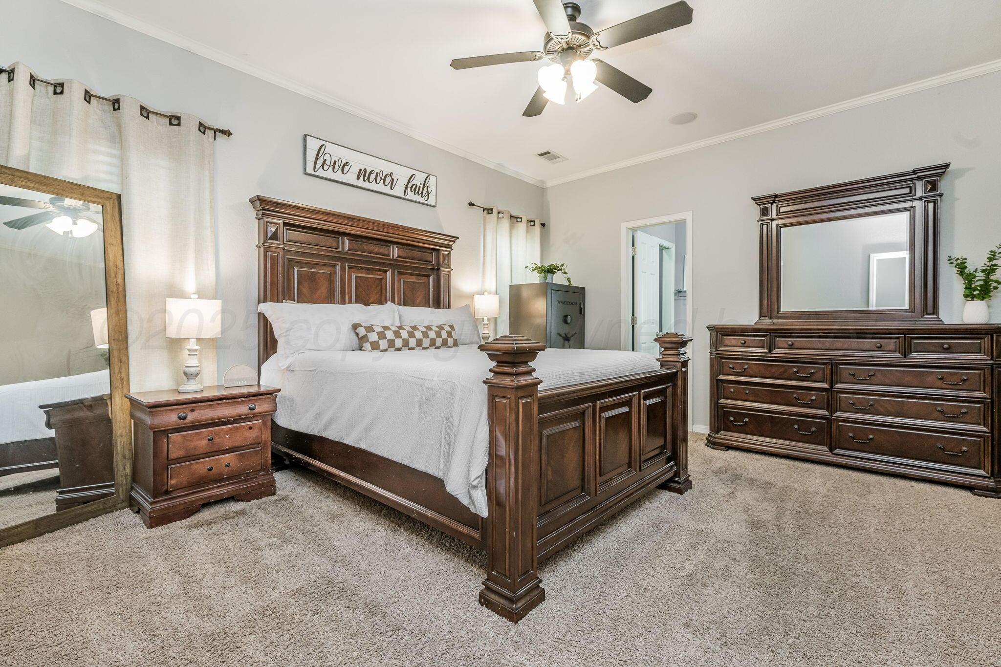 950 West Crane Road Pampa, TX 79065 - Photo 16 of 25 a bedroom with a bed and a chandelier