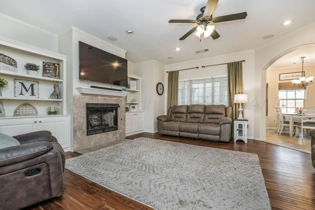 a living room with furniture a flat screen tv and a fireplace