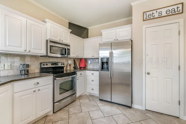 a kitchen with white cabinets stainless steel appliances and a sink