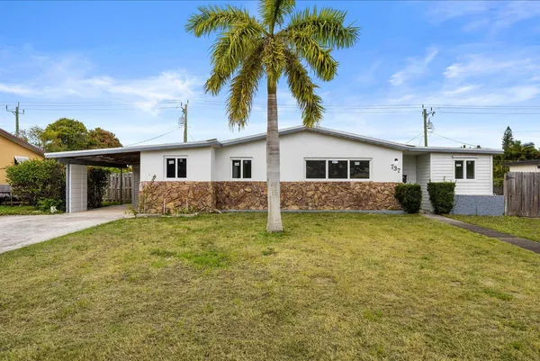 a front view of a house with a garden and yard
