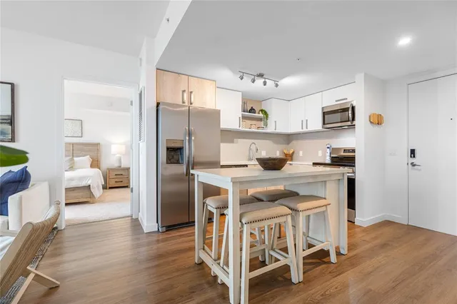 a kitchen with stainless steel appliances granite countertop a refrigerator and a stove top oven