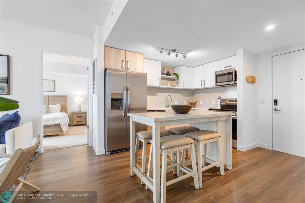 a kitchen with stainless steel appliances granite countertop a refrigerator and a stove top oven