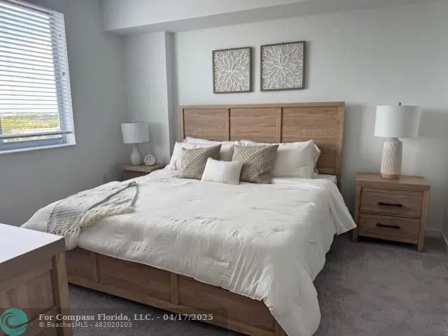 a bedroom with a bed and a lamp on dresser