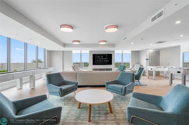 a living room with furniture and a view of kitchen