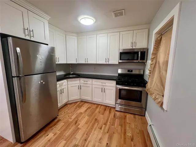 a kitchen with a refrigerator stove and white cabinets
