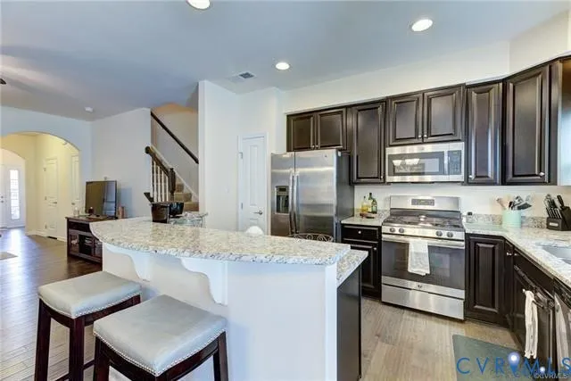 a kitchen with kitchen island a stove a sink and a refrigerator