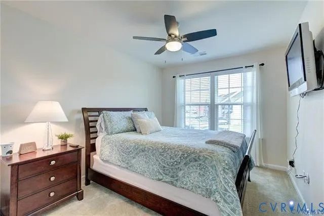 a bedroom with a bed and a flat tv screen on dresser