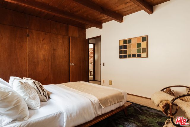 a bedroom with a bed and a painting on the wall