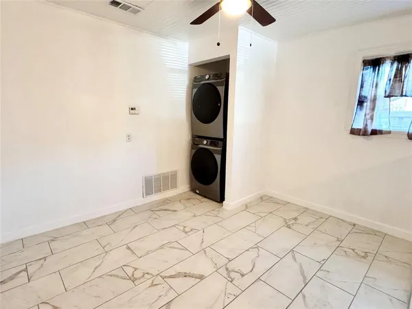 an empty room with chandelier fan