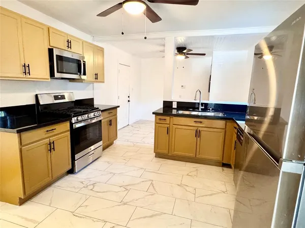 a kitchen with stainless steel appliances granite countertop a stove a sink and a microwave