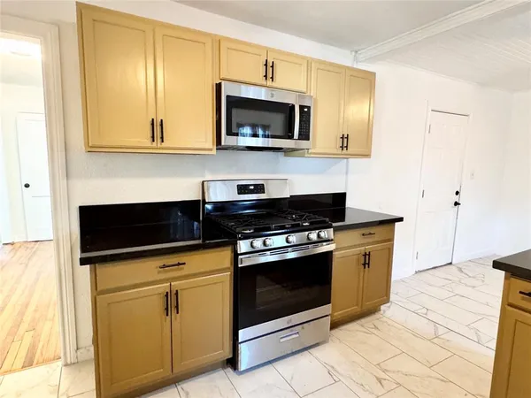 a kitchen with granite countertop a stove and a microwave