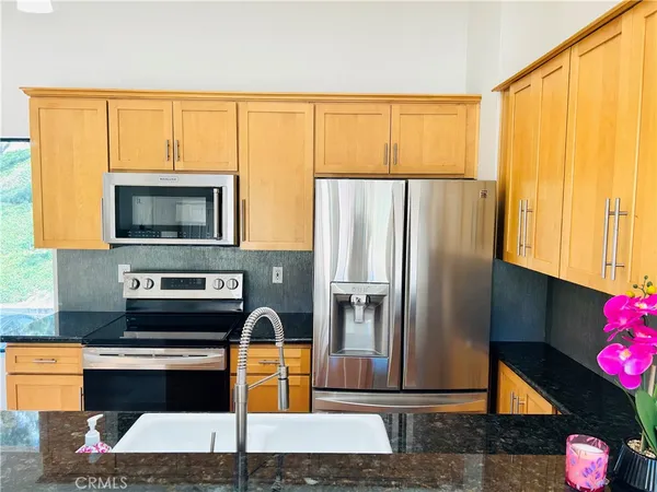a kitchen with stainless steel appliances granite countertop a refrigerator and a stove top oven