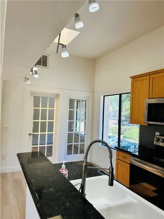 a kitchen with a stove a sink and a granite counter tops