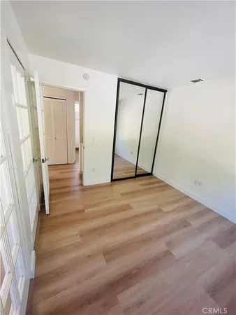 an empty room with wooden floor and entrance