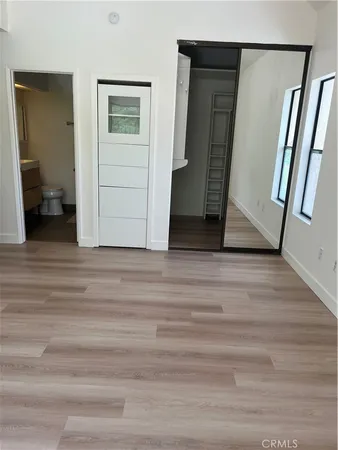 a view of a hallway with wooden floor and closet