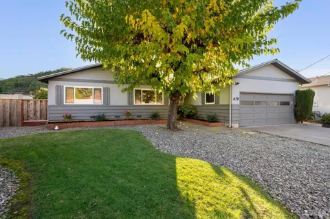 a view of house with a backyard