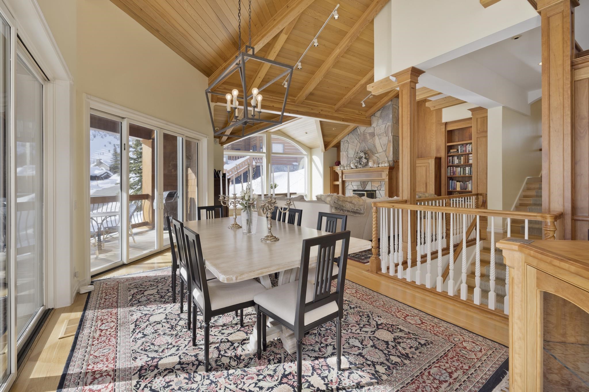370 Ranch Road Mammoth Lakes, CA 93546 - Photo 14 of 46 Dining space with a fireplace, a wooden ceiling with exposed beams, light wood-type flooring, high vaulted ceiling, and a chandelier