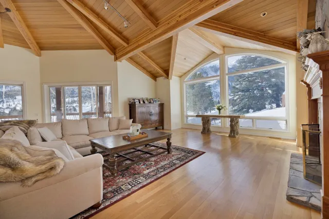 a living room with fireplace furniture and a large window