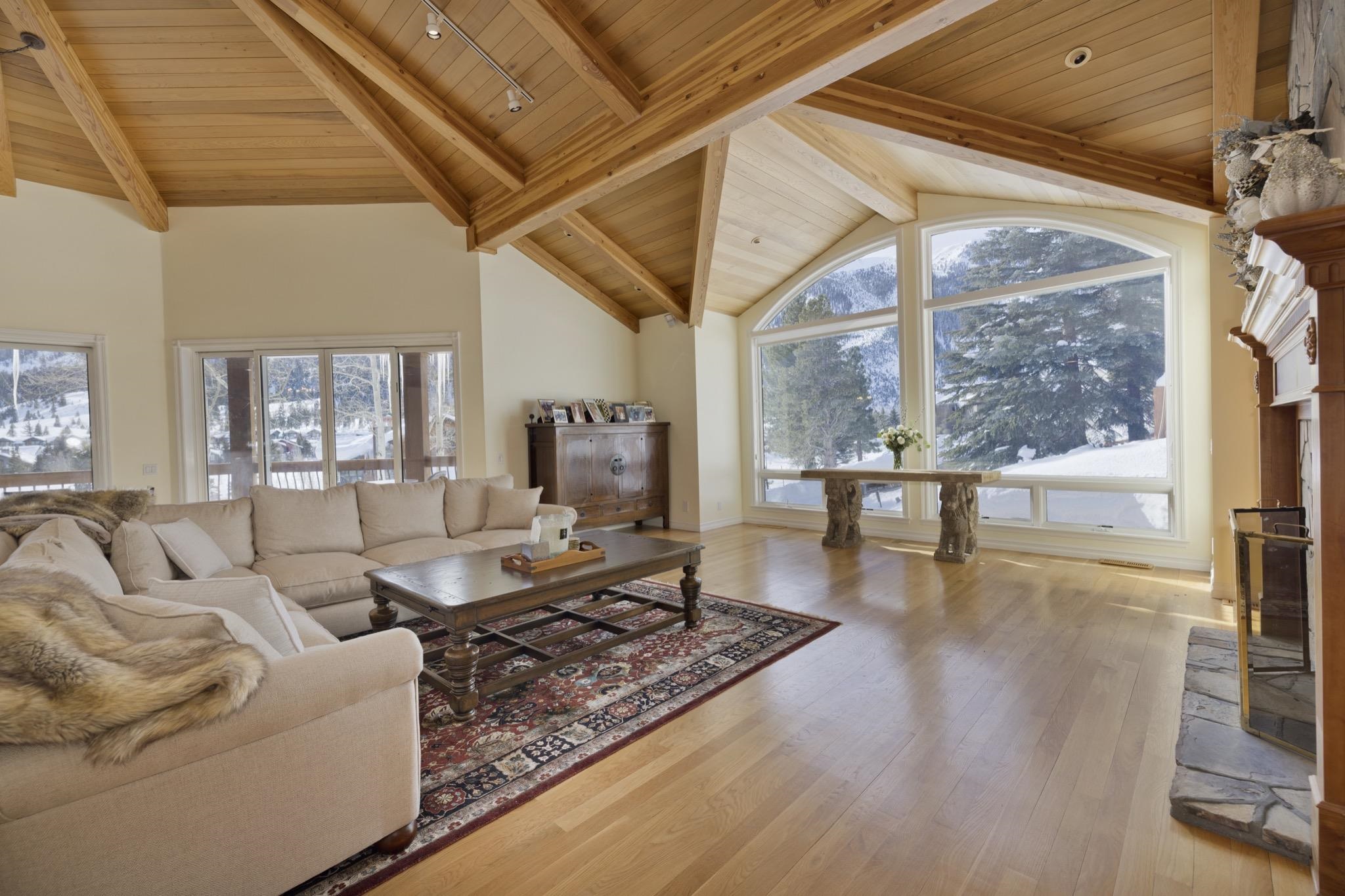 370 Ranch Road Mammoth Lakes, CA 93546 - Photo 2 of 46 Living area with a wood ceiling with exposed beams, light wood-style floors, a fireplace, healthy amount of natural light, and high vaulted ceiling