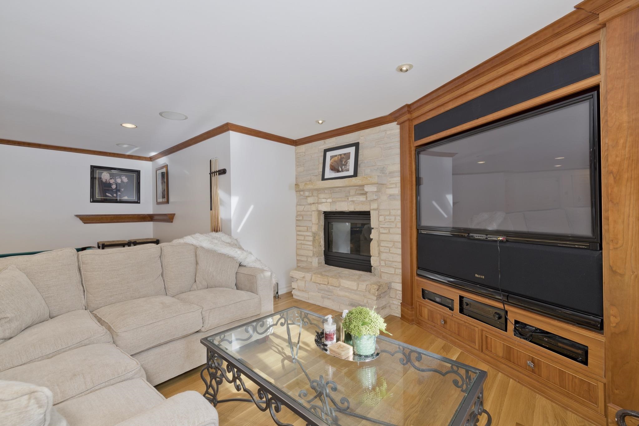 370 Ranch Road Mammoth Lakes, CA 93546 - Photo 22 of 46 Living room featuring recessed lighting, wood finished floors, ornamental molding, and a stone fireplace