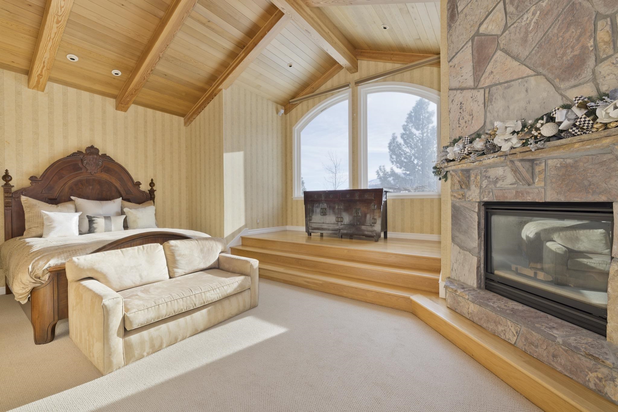 370 Ranch Road Mammoth Lakes, CA 93546 - Photo 26 of 46 Bedroom with a stone fireplace, wooden ceiling, wallpapered walls, and carpet